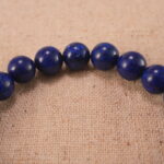 Close-up of lapis lazuli bracelet with S925 silver charm.