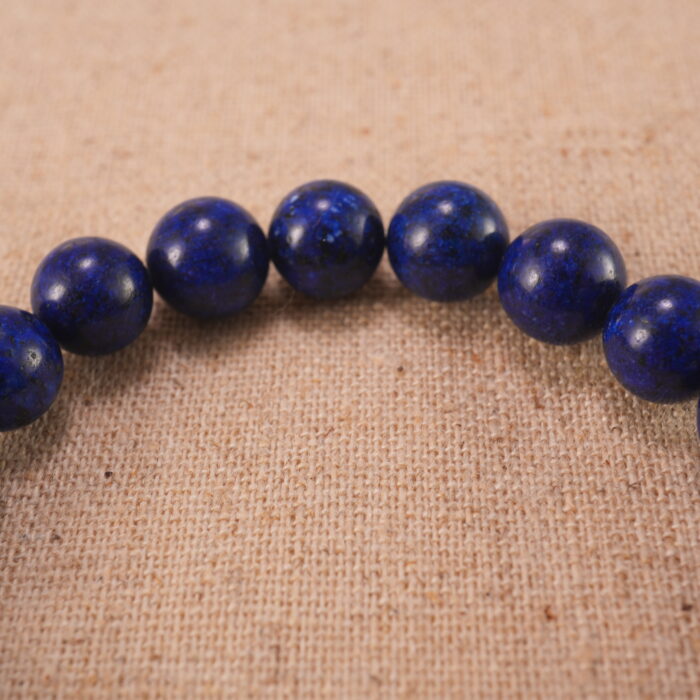 Close-up of lapis lazuli bracelet with S925 silver charm.