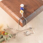 Libra zodiac necklace displayed on wooden board with citrine, lapis lazuli, and clear quartz.