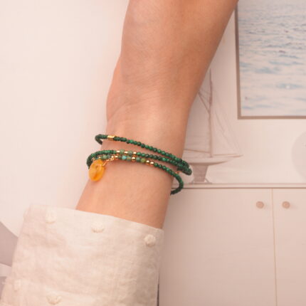 The malachite bracelet wrapped around the wrist three times, offering a bold and earthy statement look.