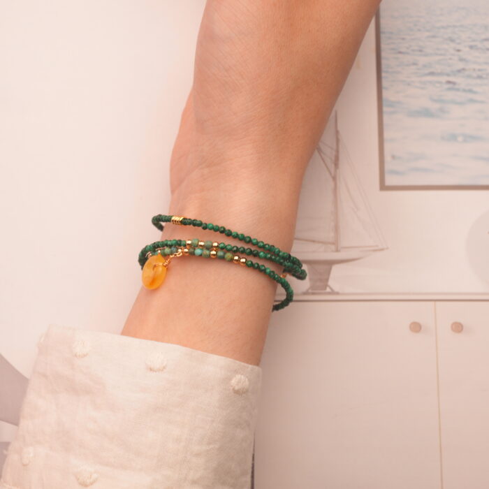 The malachite bracelet wrapped around the wrist three times, offering a bold and earthy statement look.