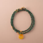 Multi-use necklace made of natural malachite beads, styled in a coiled layout to highlight its vibrant green tones.