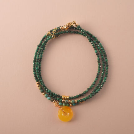 Multi-use necklace made of natural malachite beads, styled in a coiled layout to highlight its vibrant green tones.
