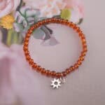 Garnet bracelet in natural light showing warm red-orange glow.