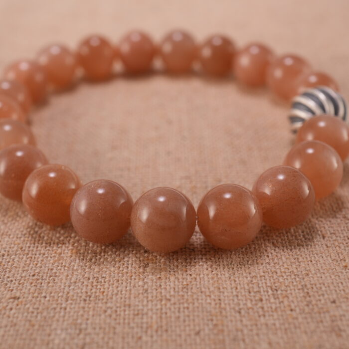 Close-up of peach moonstone bracelet with S925 silver detailing.