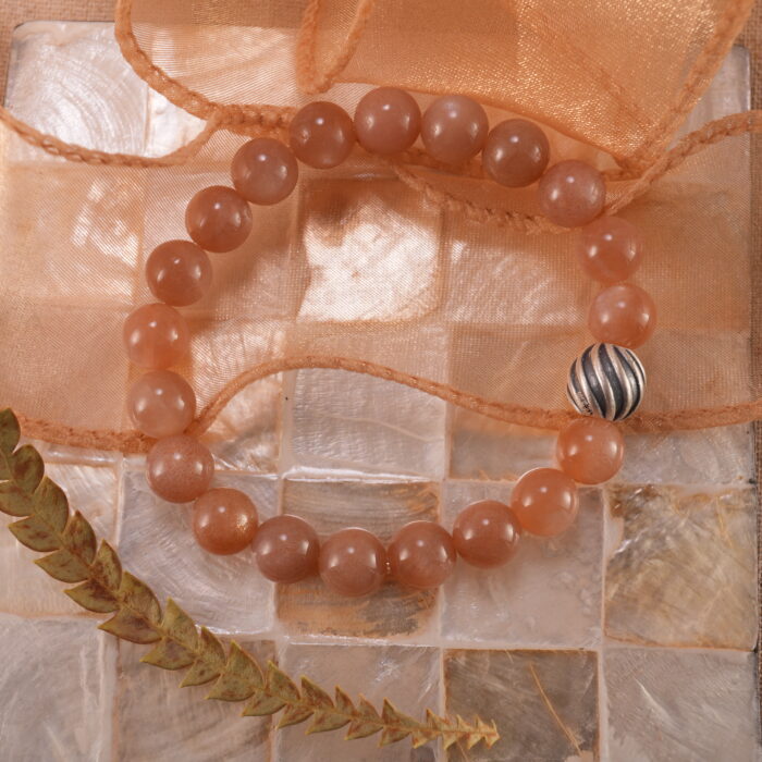 Peach moonstone S925 bracelet in warm-toned natural lighting.