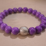 Close-up of phosphosiderite bracelet showing soft purple beads with natural luster.