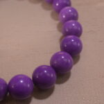 Close-up of phosphosiderite bracelet showing soft purple beads with natural luster.