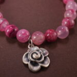 Close-up of pink chalcedony and clear quartz bracelet with smooth beads.