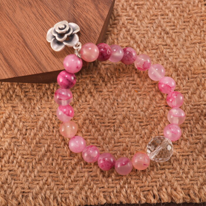 Pink chalcedony and quartz bracelet displayed in soft natural lighting.