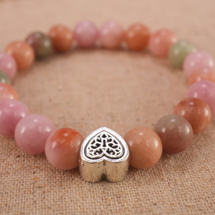 Close-up of pink Yanyuan agate bracelet with S925 silver charm.