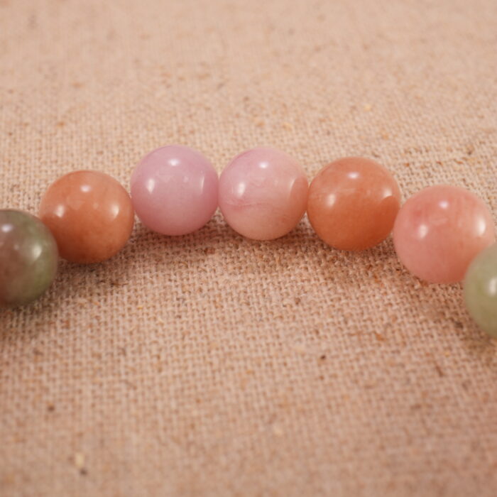 Close-up of pink Yanyuan agate bracelet with S925 silver charm.