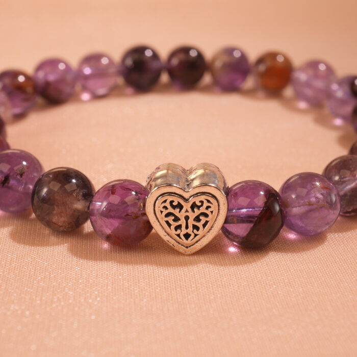 Close-up of purple phantom quartz bracelet with layered crystal inclusions.