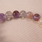 Close-up of purple phantom quartz bracelet with translucent layers.