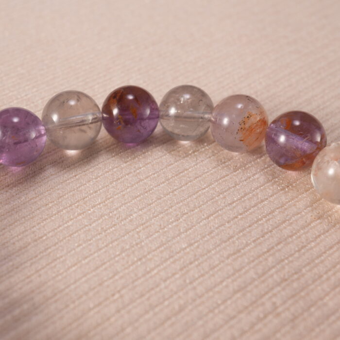 Close-up of purple phantom quartz bracelet with translucent layers.