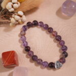 Purple phantom quartz bracelet in natural light on textured background.