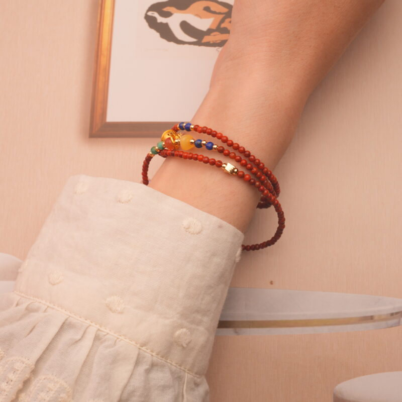 The bracelet wrapped three times around the wrist, blending the deep blue of lapis lazuli with the rich red of agate for a striking stacked look.