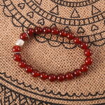 Red agate bracelet in natural light with deep red tones.