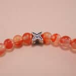 Close-up of red carnelian bracelet with silver details.