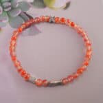Red carnelian bracelet in natural light showing vivid glow.