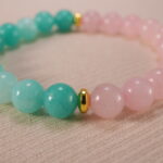 Close-up of rose quartz and amazonite bracelet in soft pastel colors.