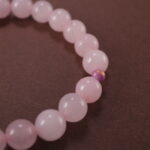 Close-up of rose quartz bracelet with soft pink translucent beads.