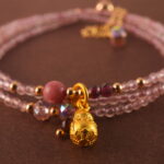 Close-up of rose quartz and rhodochrosite beads, revealing smooth surfaces and delicate natural textures.