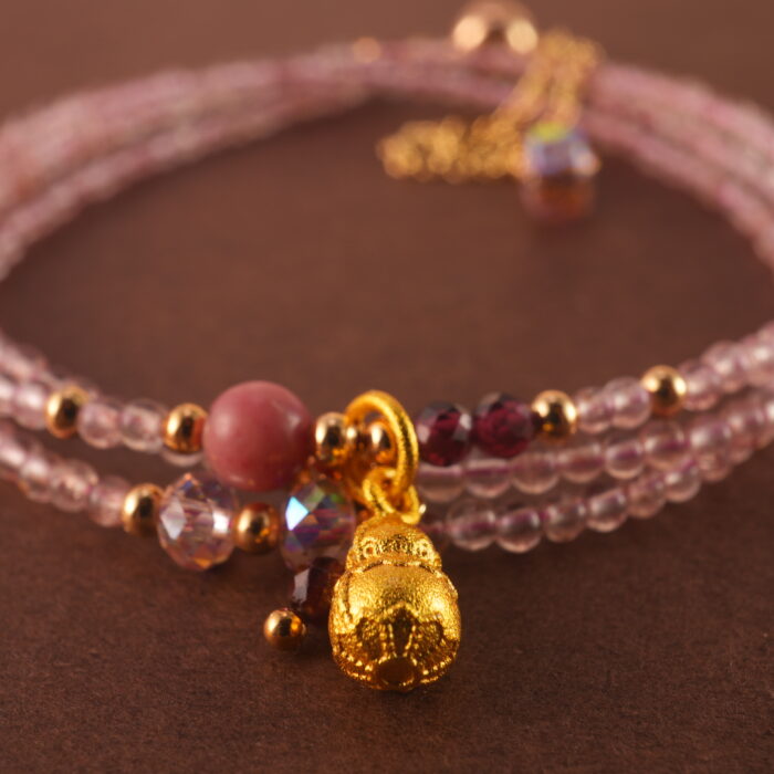 Close-up of rose quartz and rhodochrosite beads, revealing smooth surfaces and delicate natural textures.