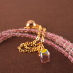 Close-up of rose quartz and rhodochrosite beads, revealing smooth surfaces and delicate natural textures.