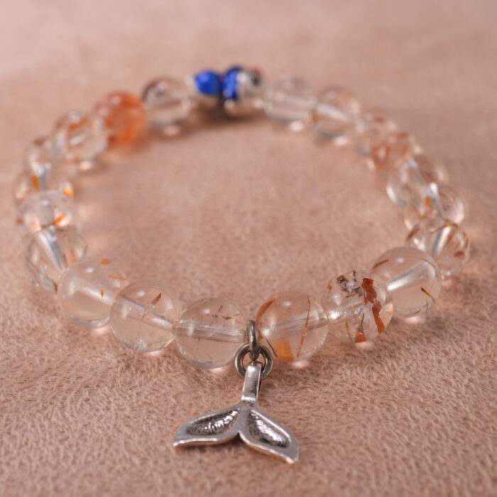 Close-up of rutilated quartz bracelet with golden needle inclusions and S925 silver.