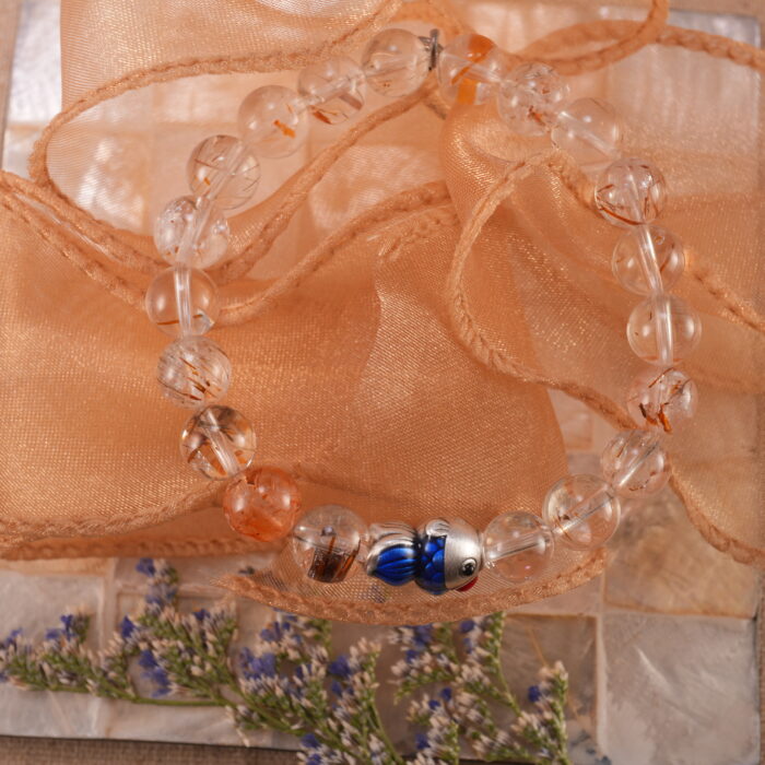 Rutilated quartz bracelet shown in natural light highlighting golden threads.