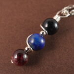 Close-up of Scorpio necklace showing obsidian, lapis lazuli, and garnet beads.