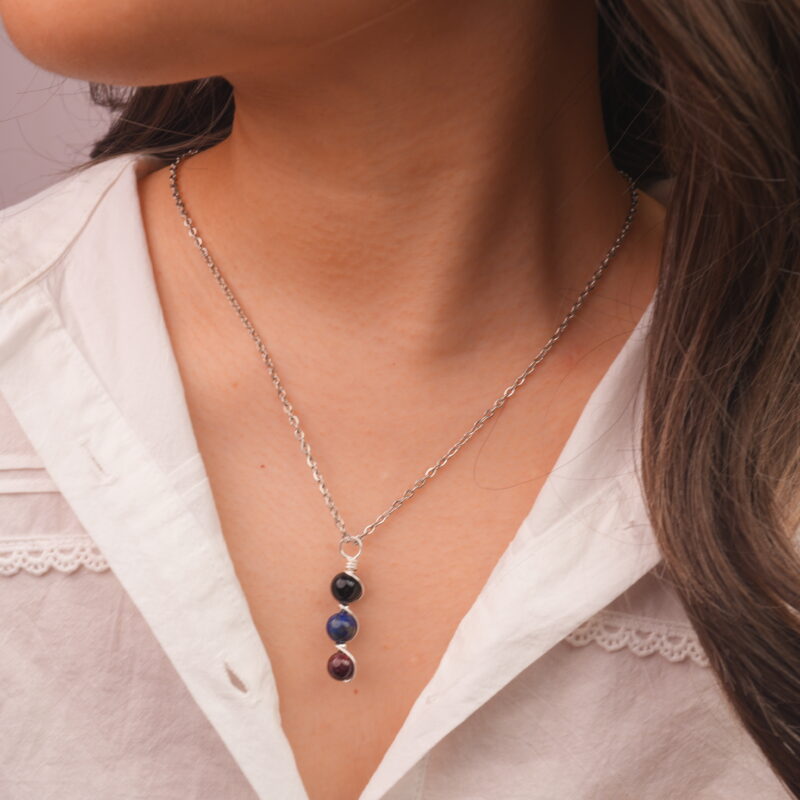 Model wearing Scorpio zodiac necklace with obsidian, lapis lazuli, and garnet.
