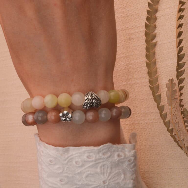 Model wearing Afghan jade and moonstone bracelets stacked together.