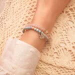 Model wearing alashan agate and rose quartz stacked bracelets.