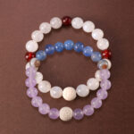 Main image of stacked bracelets in purple, white, and red tones.