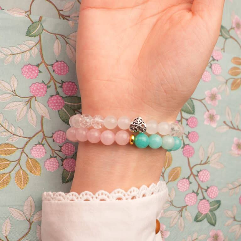 Model wearing gemstone bracelet stack in soft, feminine colors.