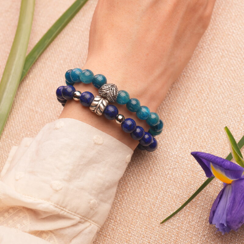 Model wearing blue apatite and lapis lazuli stacked bracelets.
