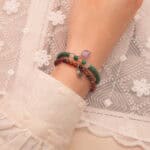 Model wearing gemstone stack in bold contrasting tones.