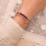 Model wearing pastel gemstone bracelet stack.