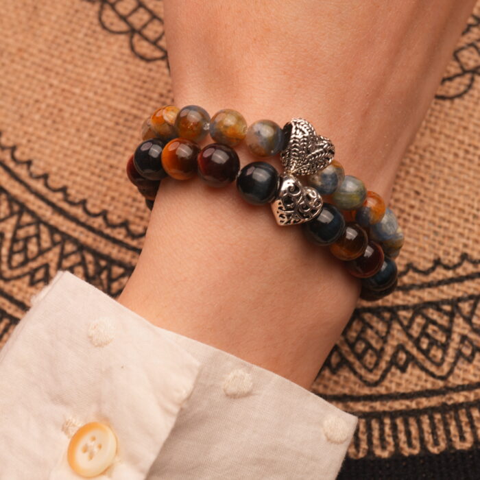 Model wearing gemstone stack in bold blue and brown tones.