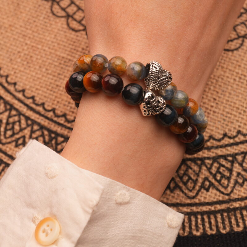 Model wearing gemstone stack in bold blue and brown tones.