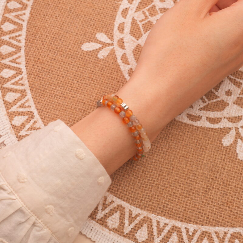 Model wearing gemstone stack with soft contrast tones.