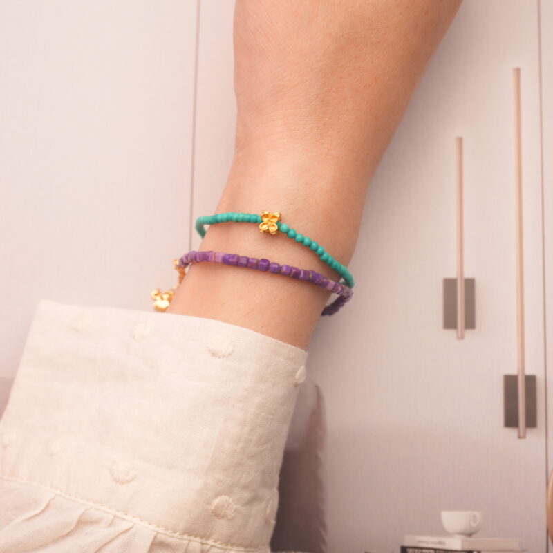 Model wearing purple chalcedony and turquoise bracelets stacked together.