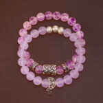 Main product image featuring two stacked amethyst crystal bracelets.