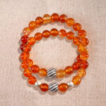 Main image featuring two stacked flower red agate bracelets.
