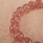 Close-up of strawberry quartz bracelet with S925 silver detail.