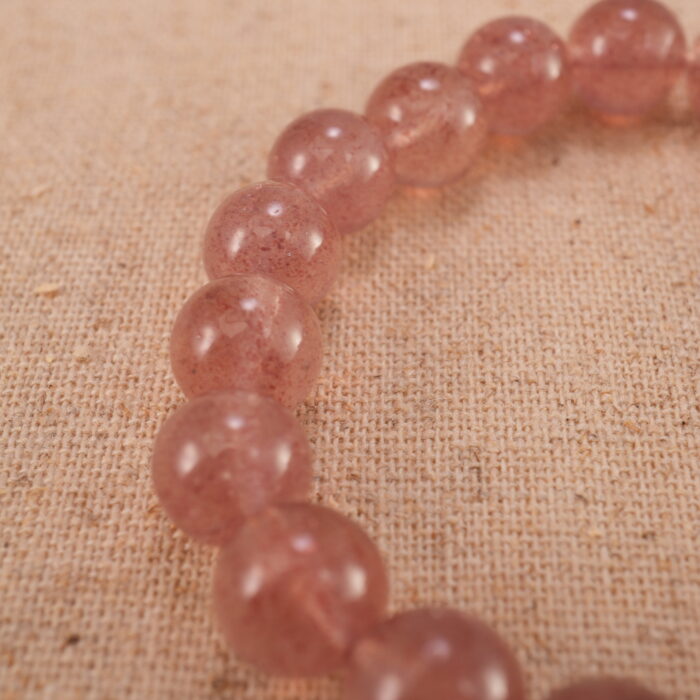 Close-up of strawberry quartz bracelet with S925 silver detail.