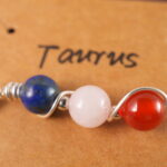 Close-up of Taurus necklace showing lapis lazuli, clear quartz, and red agate beads.