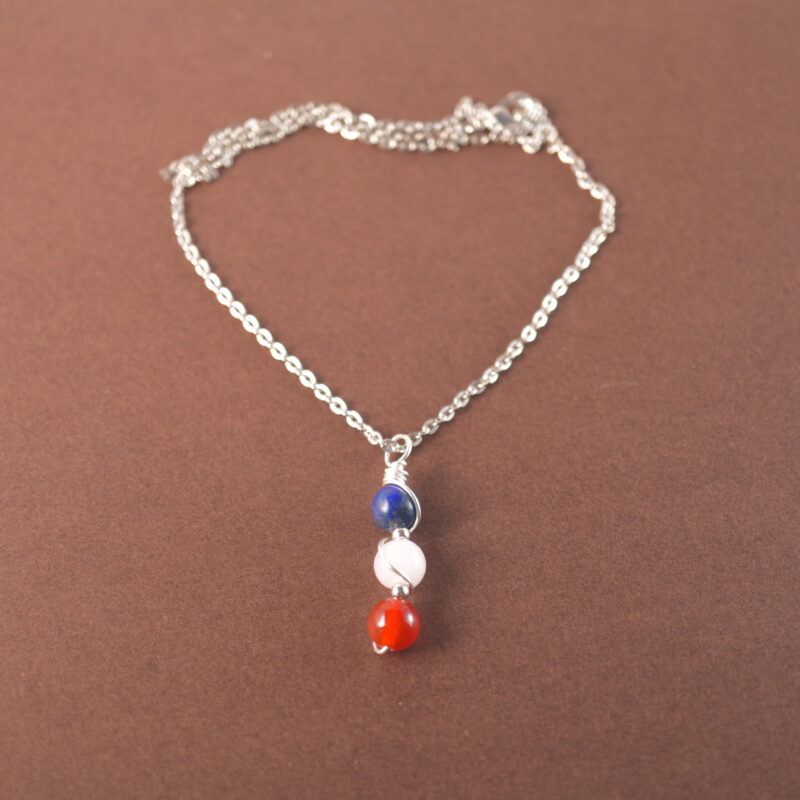 Taurus zodiac necklace with lapis lazuli, clear quartz, and red agate gemstones.